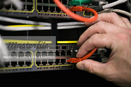 Technician inserting wire to server