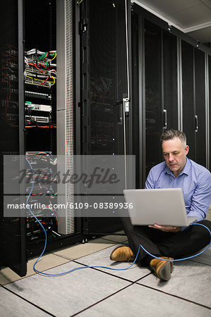 Technician using laptop to analyse server