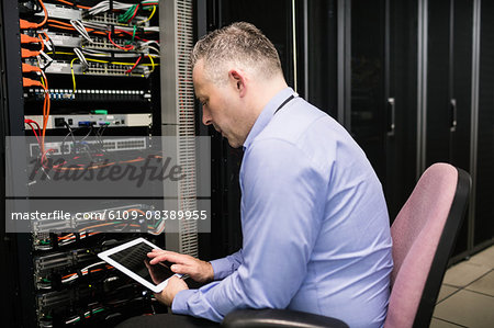 Technician using tablet in server room