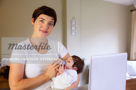 Smiling mother feeding her baby