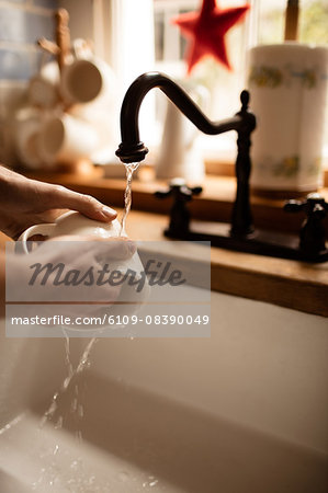 Man washing his cup in kitchen