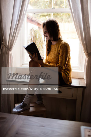 Young woman sitting on table studying