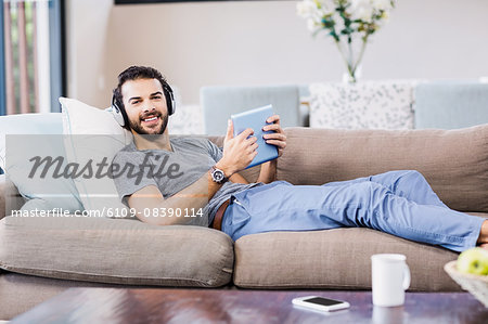 Handsome man using tablet and headphones