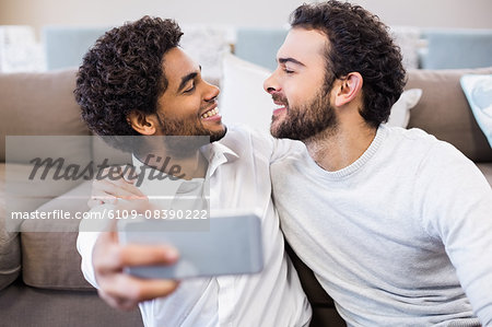 Happy gay couple taking selfie