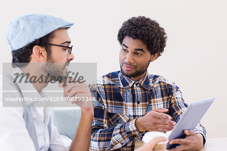Smiling gay couple using tablet