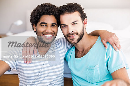 Happy gay couple sitting on the floor