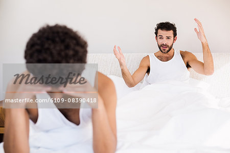 Homosexual couple having argument on bed