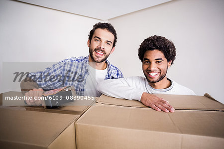 Happy gay couple closing big boxes