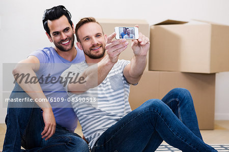 Gay couple taking selfie in their new home