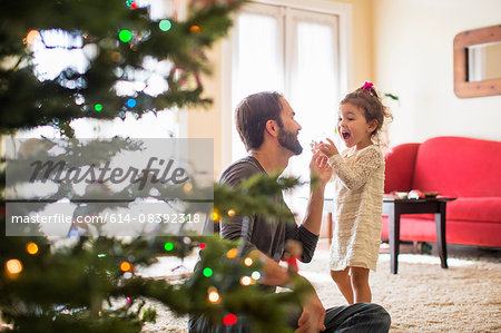 Father and daughter decorating christmas tree