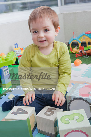 Baby boy stacking playing blocks at home