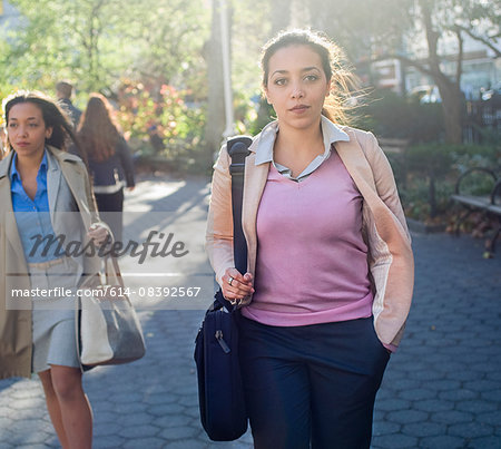 Young woman walking through city park