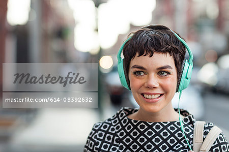 Mid adult woman, retro clothing, wearing headphones, outdoors