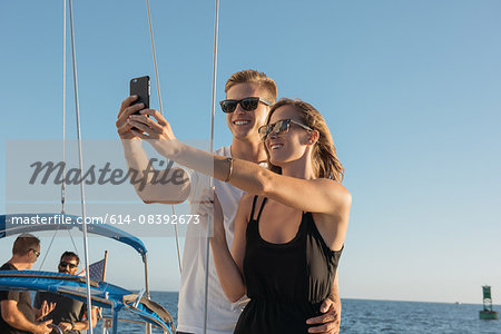 Couple taking selfie on sailboat, San Diego Bay, California, USA