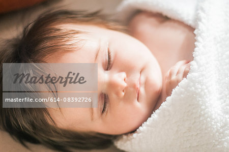 High angle view of sleeping baby girl wrapped in blanket