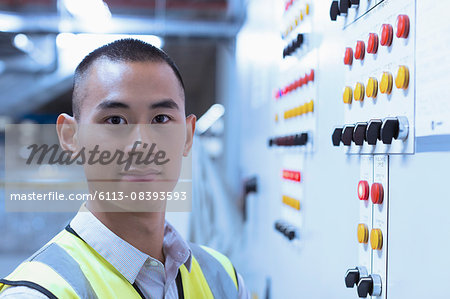 Portrait confident worker at control panel in factory