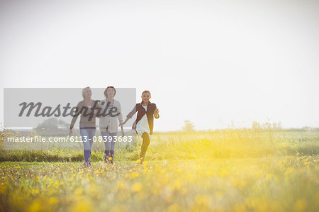 Multi-generation women walking in sunny meadow