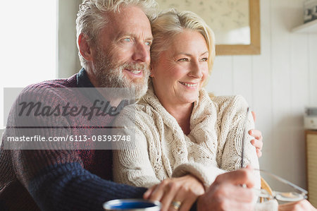 Smiling senior couple hugging and looking away