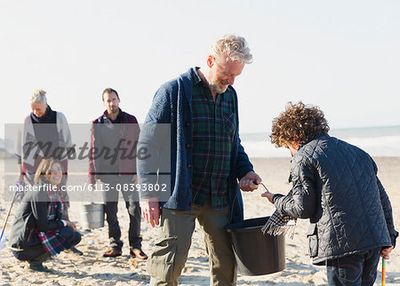 Multi-generation family clamming on sunny beach