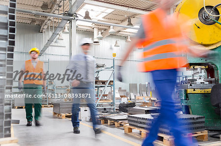 Engineer and works walking in factory