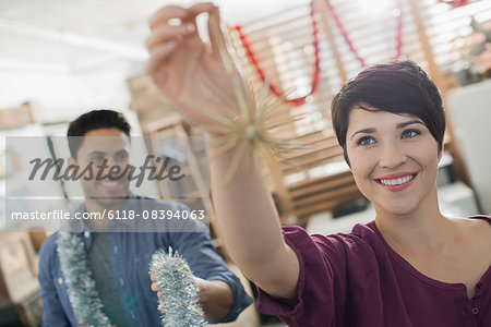 Christmas decorations. A man and woman holding tinsel and decorations.