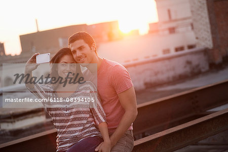 A couple on a rooftop terrace taking a selfy.