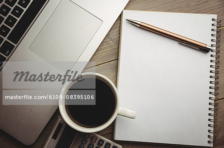 Overhead of notepad with coffee and calculator