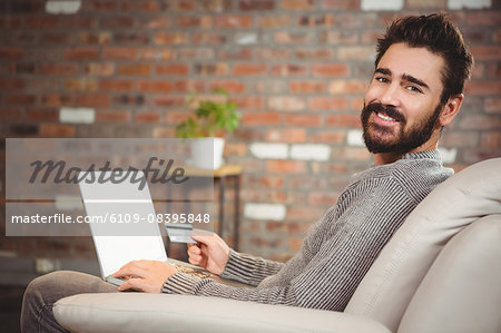 Portrait of happy man shopping online at home