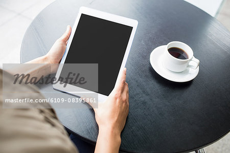 Pretty student using tablet in cafe