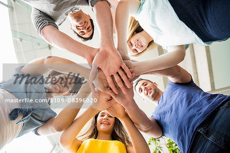 Students putting hands together in unity Students putting hands together in unity
