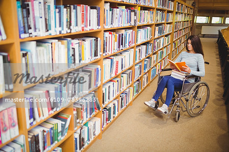 Disabled female student reading book