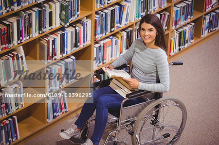 Disabled female student smiling while reading book