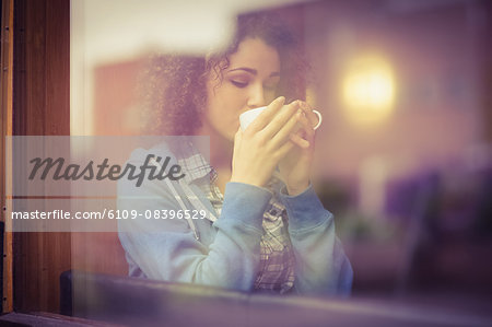 Pretty student sitting by the window having coffee