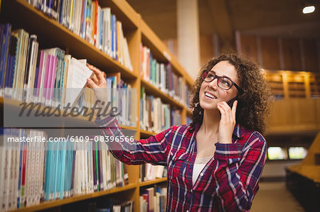 Pretty student in the library taking book