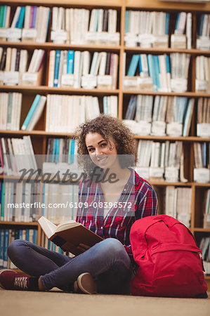 Pretty student in the library reading book