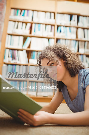 Pretty student in library reading book