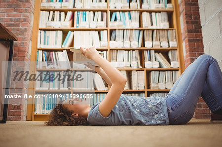 Pretty student in library reading book
