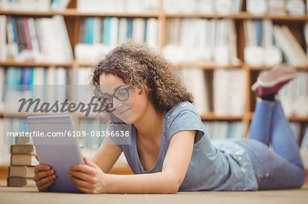 Pretty student in library using tablet