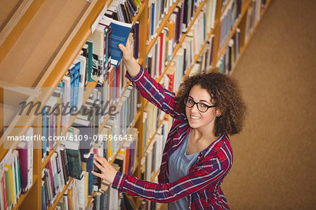 Pretty student in library taking book