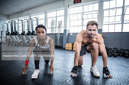 Muscular couple doing body stretching