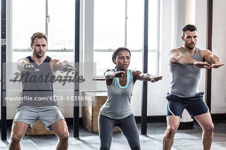 Three fit athletes stretching together Three fit athletes stretching together