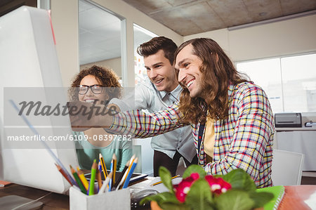 Happy business people pointing at computer