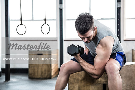 Fit man lifting heavy black dumbbell