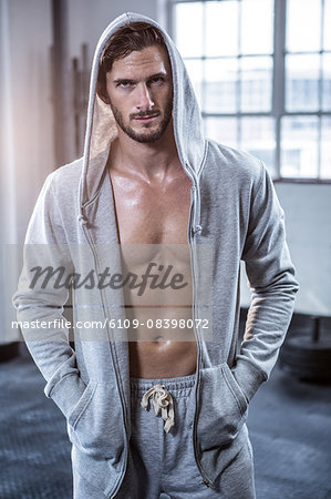 Fit shirtless man with hooded jumper