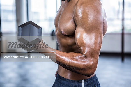 Fit man lifting heavy black dumbbells