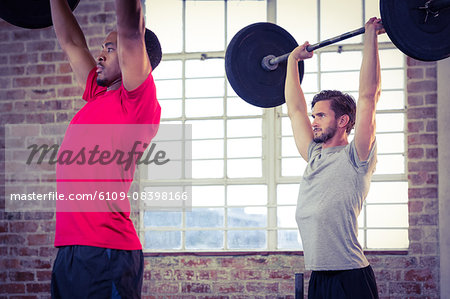 Fit people lifting barbell weight