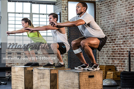 Fit people doing squat jumps