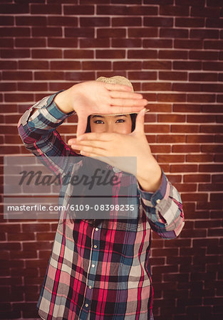 Attractive hipster taking picture with hands