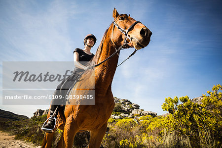 Young happy woman riding her horse