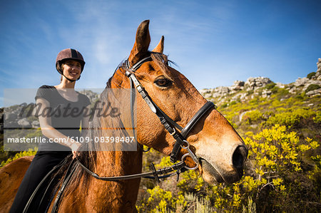 Young happy woman riding her horse